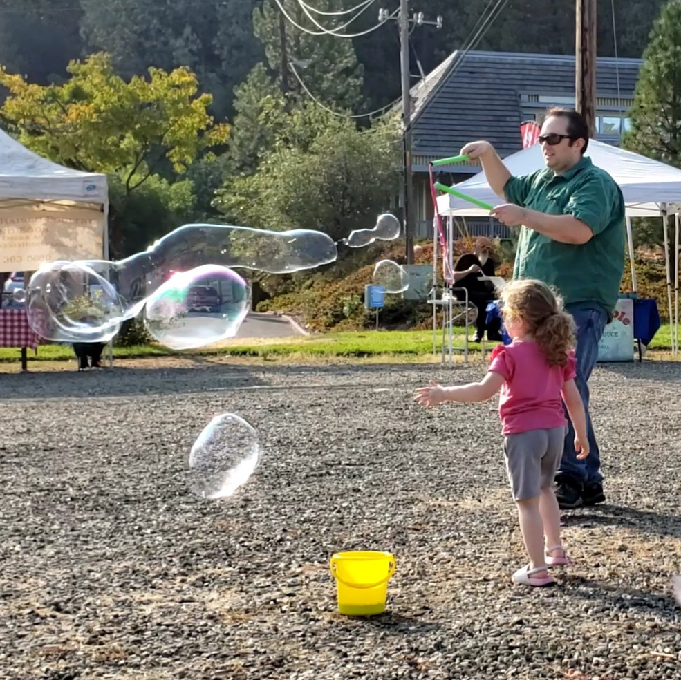 father and child play with bubble solution